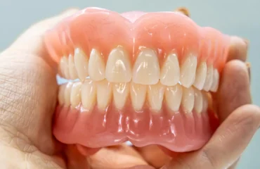 protesis-dental-y-encias-dentadura-completa-mano Prótesis dental y encías: dentadura completa sostenida en la mano